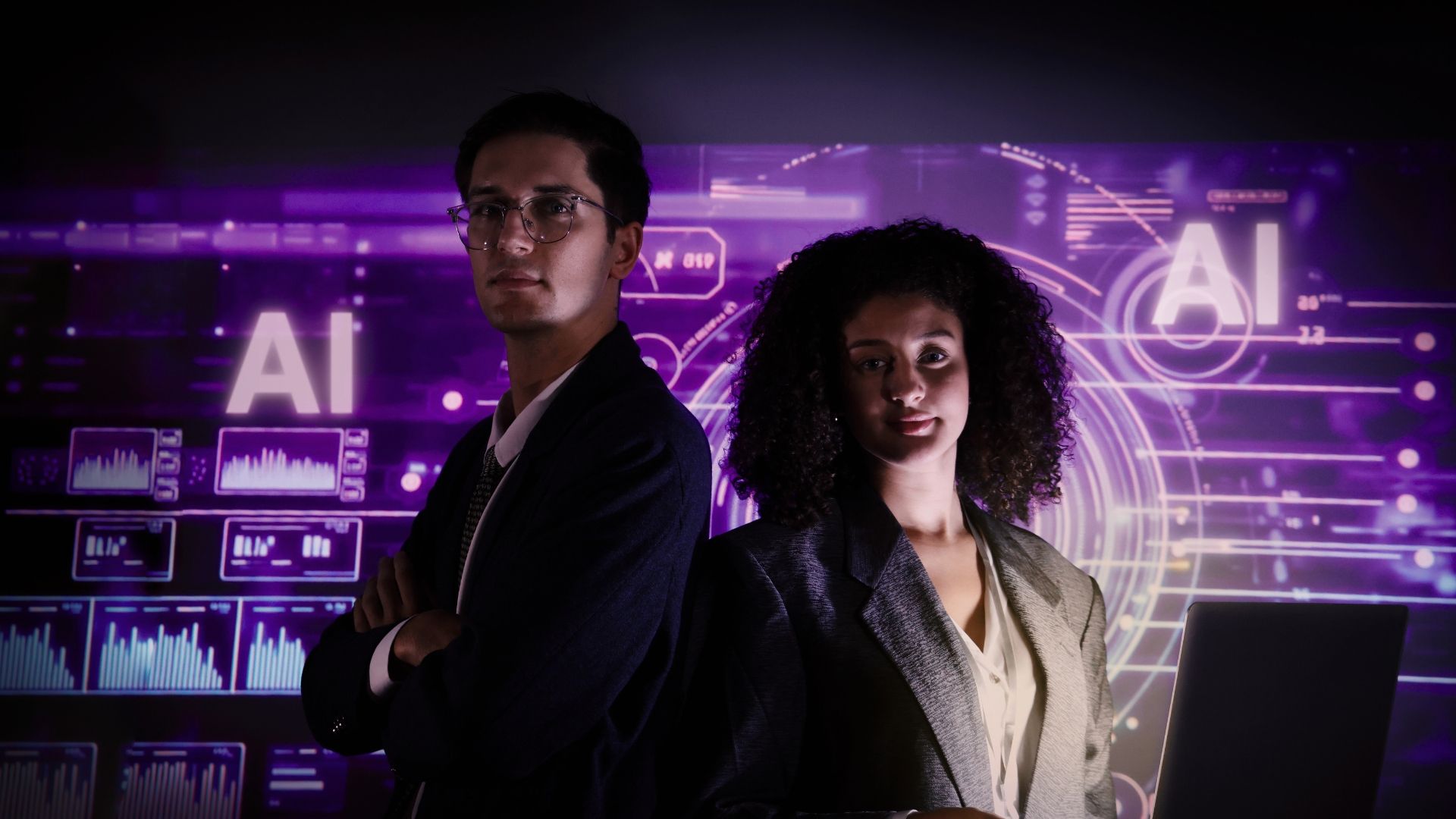 Man and woman stand in front of a purple digital AI display.