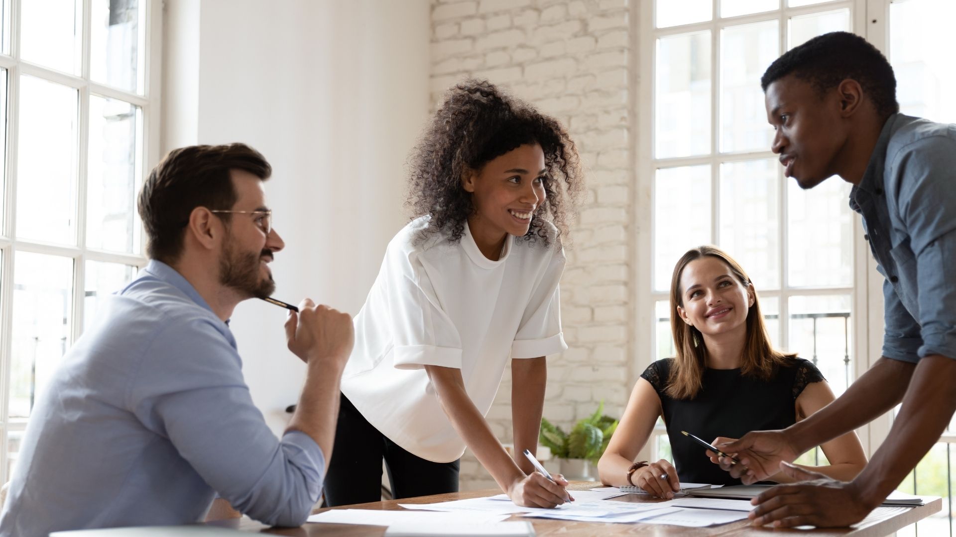 Graduate students talk to each other around a table