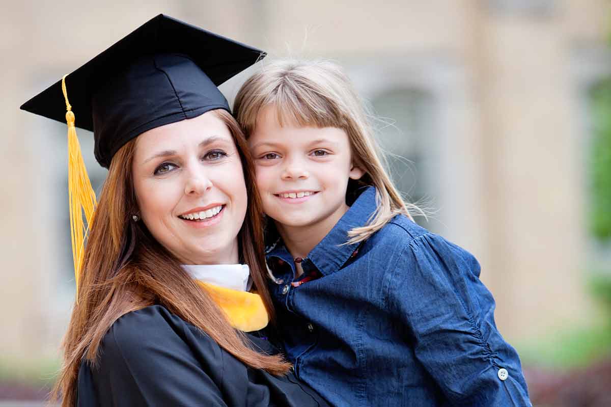 A graduate poses with her daughter at graduation.