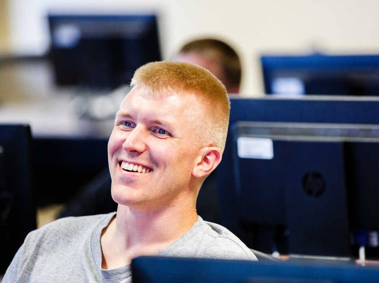 A graduate student smiles during class. 